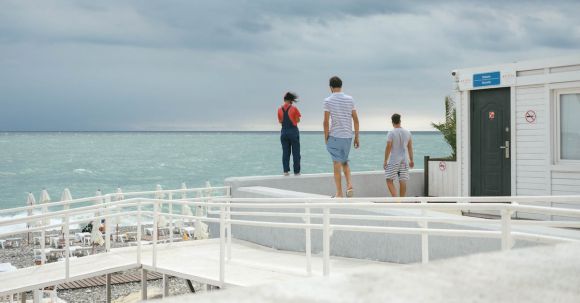 Luxury Destinations - Three People Standing on White Surface Near Body of Water