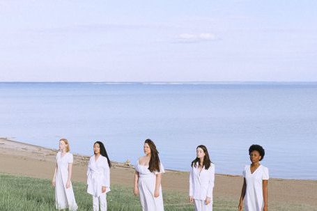 Diverse Landscapes - Women In White Standing on Green Grass Field Near Body of Water